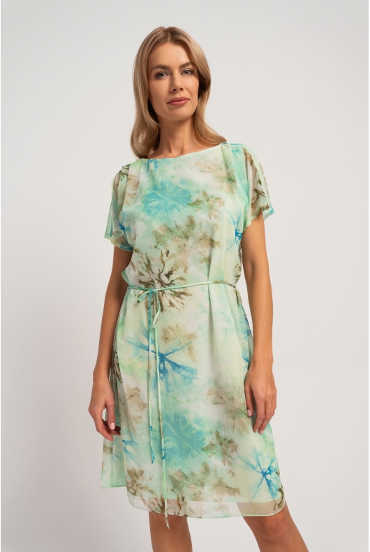 Miętowa sukienka midi z letnim printem, o prostym kroju, wiązana w talii. Stylizacja na wiosnę i lato.