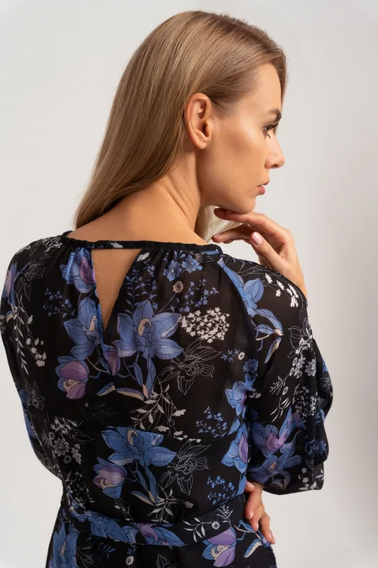 Czarna sukienka midi z kwiecistym niebieskim wzorem, luźnymi balonowymi rękawami i wiązaną talią. Dekolt v na plecach.