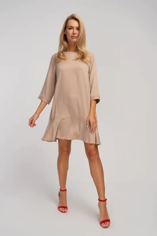 Beżowa trapezowa sukienka mini oversize do kolana w kształcie litery A z rękawami 3/4. Stylizacja wiosenna.