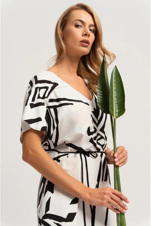 Biała sukienka maxi w czarny print. Dekolt w kształcie v, wiązanie w talii.