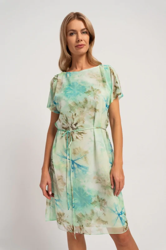 Miętowa sukienka midi z letnim printem, o prostym kroju, wiązana w talii. Stylizacja na wiosnę i lato.
