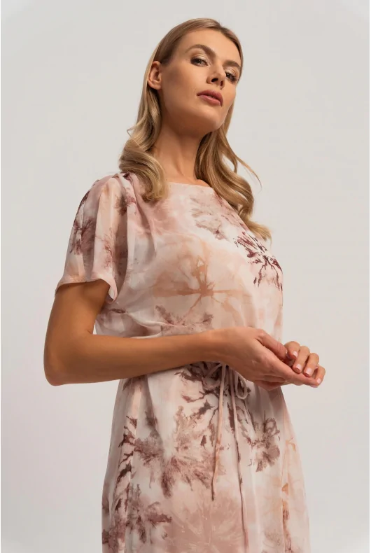 Beżowa sukienka midi z letnim printem, o prostym kroju, wiązana w talii. Stylizacja na wiosnę i lato.