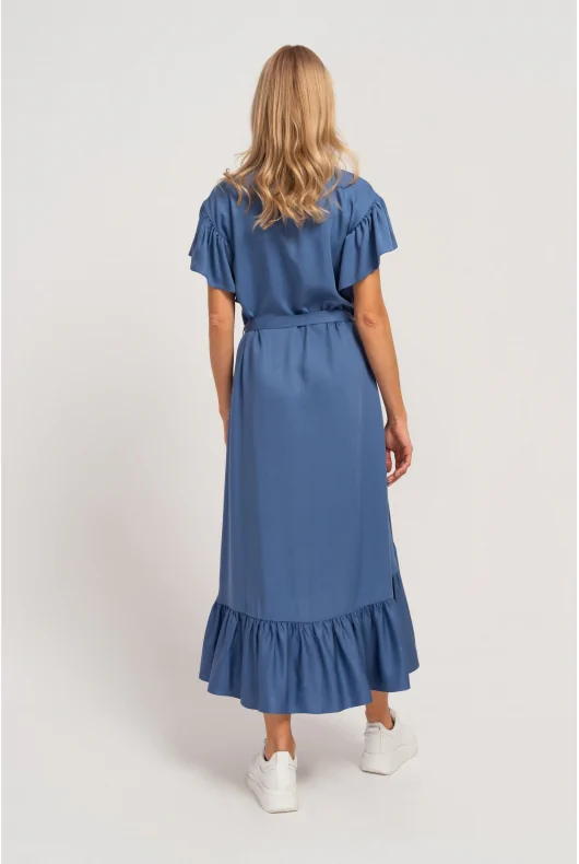 Długa niebieska sukienka z wiązaną talią, podkreślająca kobiecą figurę. Elegancka i luźna forma.