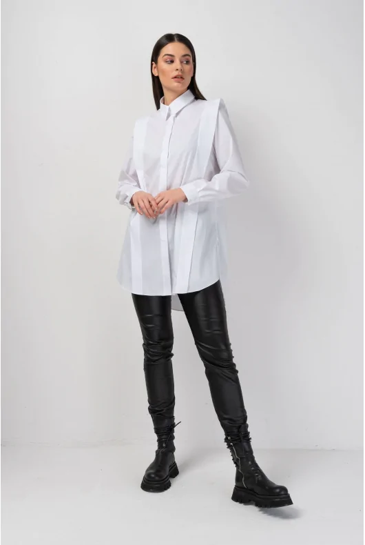 Długa oversizowa koszula damska z długim rękawem i ozdobnymi zakładkami. W kolorze białym